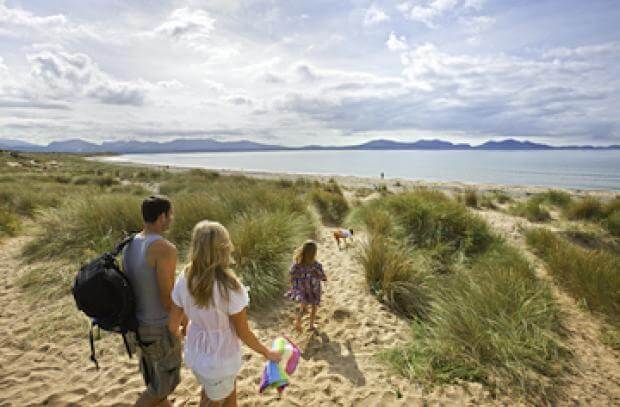 family walking through the dunes to the sea